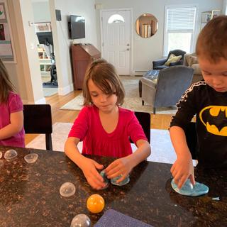 Three very happy and occupied kids playing with slime