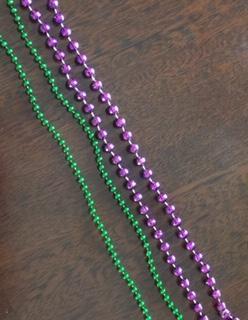 Green necklace is advertised product. Purple beads are standard Mardi Gras beads from another source