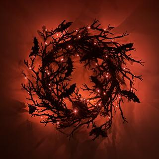Bat wreath lit up in a dark room
