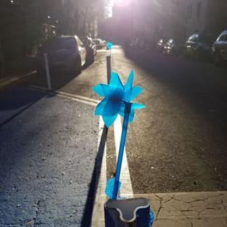 Pinwheel on 103rd taped to plastic bollard.