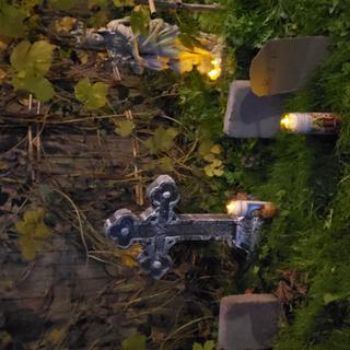 Mini cemetery in my front yard with Celtic Cross Tombstone and electric candles.