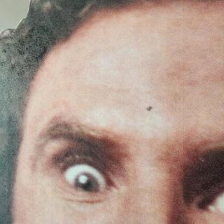 You can see the weird shiny/matte in his hair, the dark splotch, and print line through his forehead