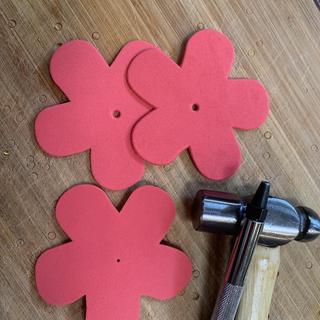 Used to to punch larger hole for curling ribbon. Bottom flower is how they come.