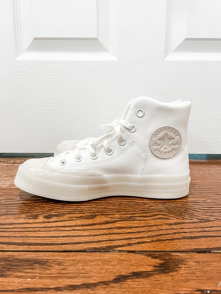 I love the spin that these take on classic Chucks high tops! The different textures (canvas against the glossy sole) make these shoes super fun and easy to dress up and down! 

They’re extremely comfortable and maintain their structure so that they stay “high” all day while you wear them. I will say that I don’t think they run a size larger, they seemed totally true to size (I am normally a 7.5, wore a 7 and feel I could have gone up a half size).

I love the colors chosen for the iconic converse star and the “Chuck Taylor” scripted on the side. They are almost elegant and I could even see a someone wearing these as part of their wedding ensemble (hello after party!)

Overall, I love the look of these but recommend sticking with your typical side for maximum comfort.