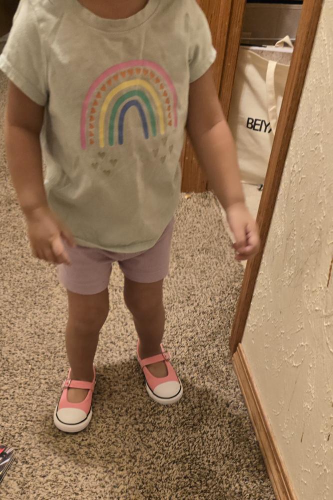 The fit was slightly too big for my daughter since I sized up to an 8 instead of her usual 7, but the width fit perfectly. Despite the size, she still enjoyed wearing the shoes, and I’m excited for her to grow into them because they’re so cute and dainty! The design is absolutely adorable, and I especially loved the velcro buckle—it’s such a convenient feature that makes putting them on and taking them off so much easier than a traditional buckle. The fabric is the classic Converse material, which is both stylish and durable. Overall, I loved how cute and functional they are, and I wouldn’t change a thing except choosing a more accurate size next time!