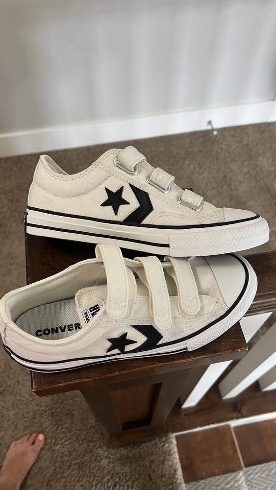 I'm delighted with the Converse Star Player 76 3V Vintage White/Black/Egret kids shoe for my son! They are the perfect back to school shoe! Converse is always making quality products and I’ve never been disappointed. 

The durable fabric in these shoes ensures they can handle my sons active playtime, while the classic style and design make them a timeless look that will go with anything. The consistent fit is spot-on, and they go perfectly with any outfit, making them a versatile addition to his wardrobe. I’d give them a week or so of consistent wear to break in and mold to your foot. 

The vintage star on the side adds a touch of charm, and the velcro closure is a godsend for quick exits out the door with kids. Sizing down a half size was the right call, as Converse tend to run large. These shoes have become his go-to for everyday wear, and I appreciate their practicality and style. All in all, these shoes are another win for Converse!